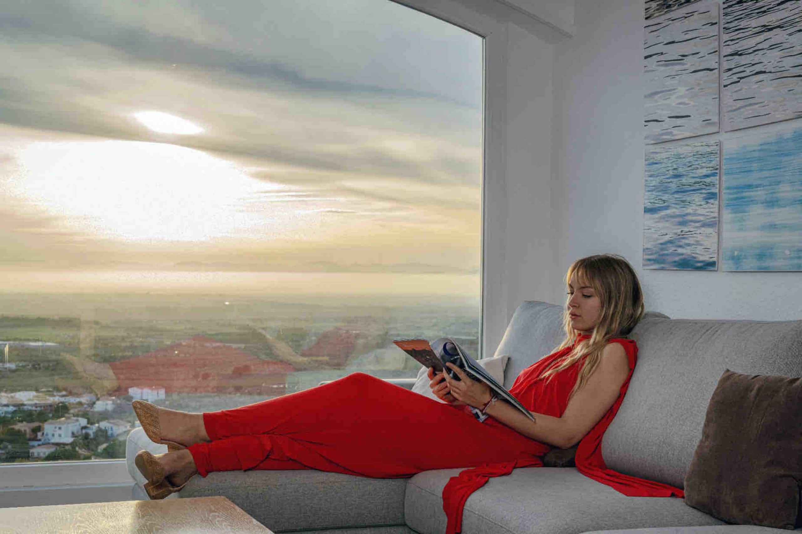 Reading on the sofa, the bay framed by the curved panoramic window
