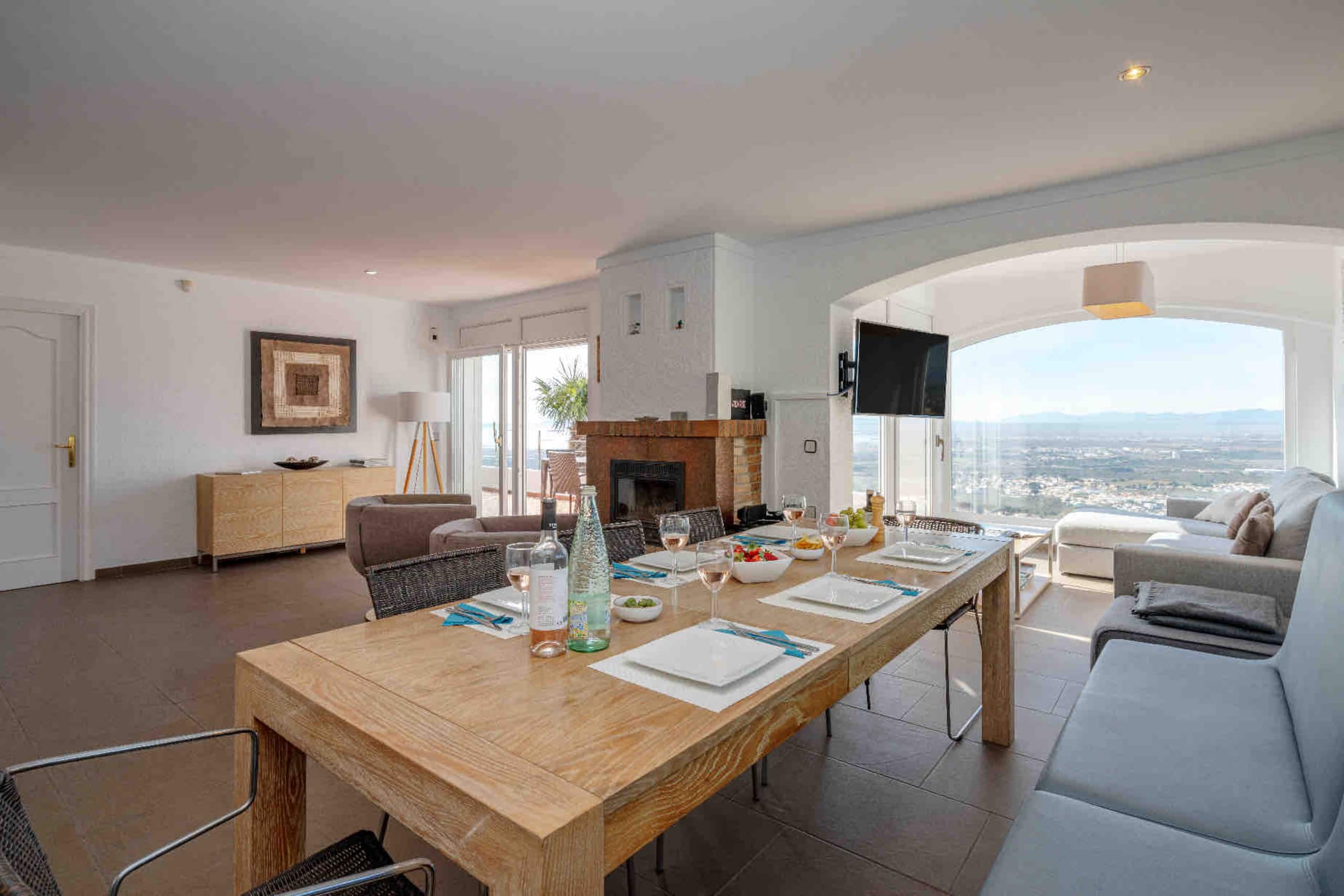 Dining table set for lunch with fireplace and view beyond
