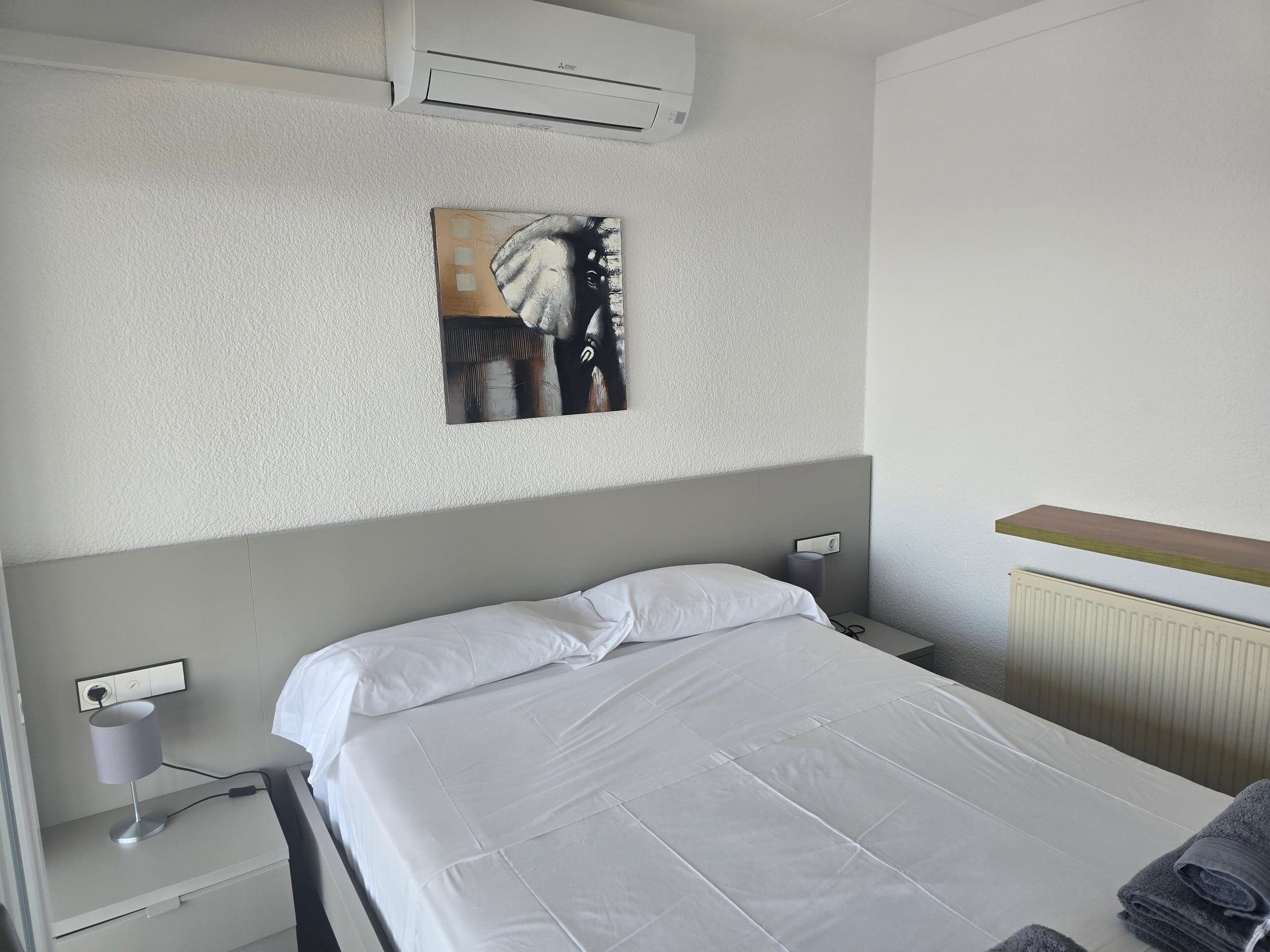 Bedroom with double bed and original painting above