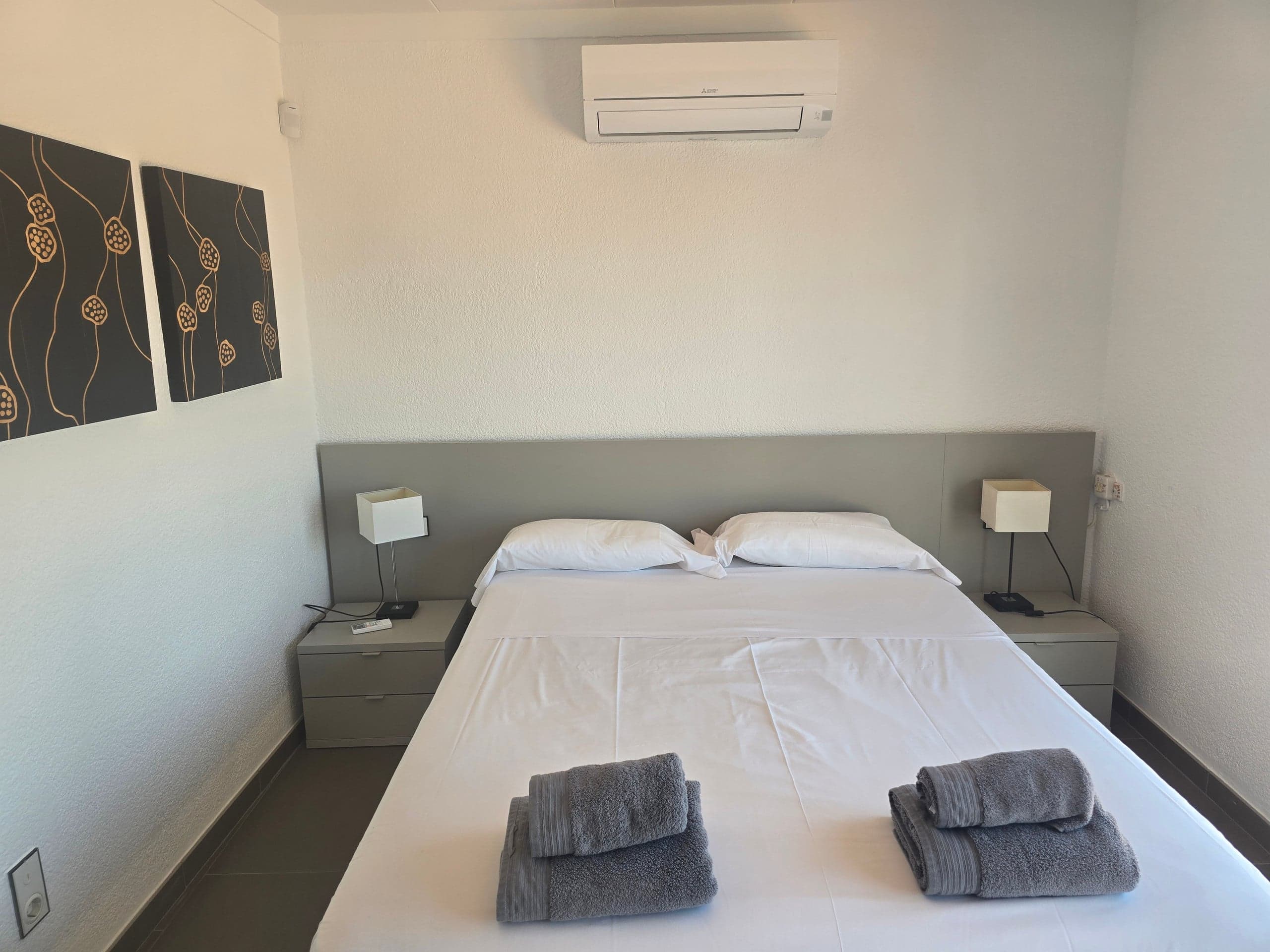 Twin bedroom with bedside lamps and fresh towels