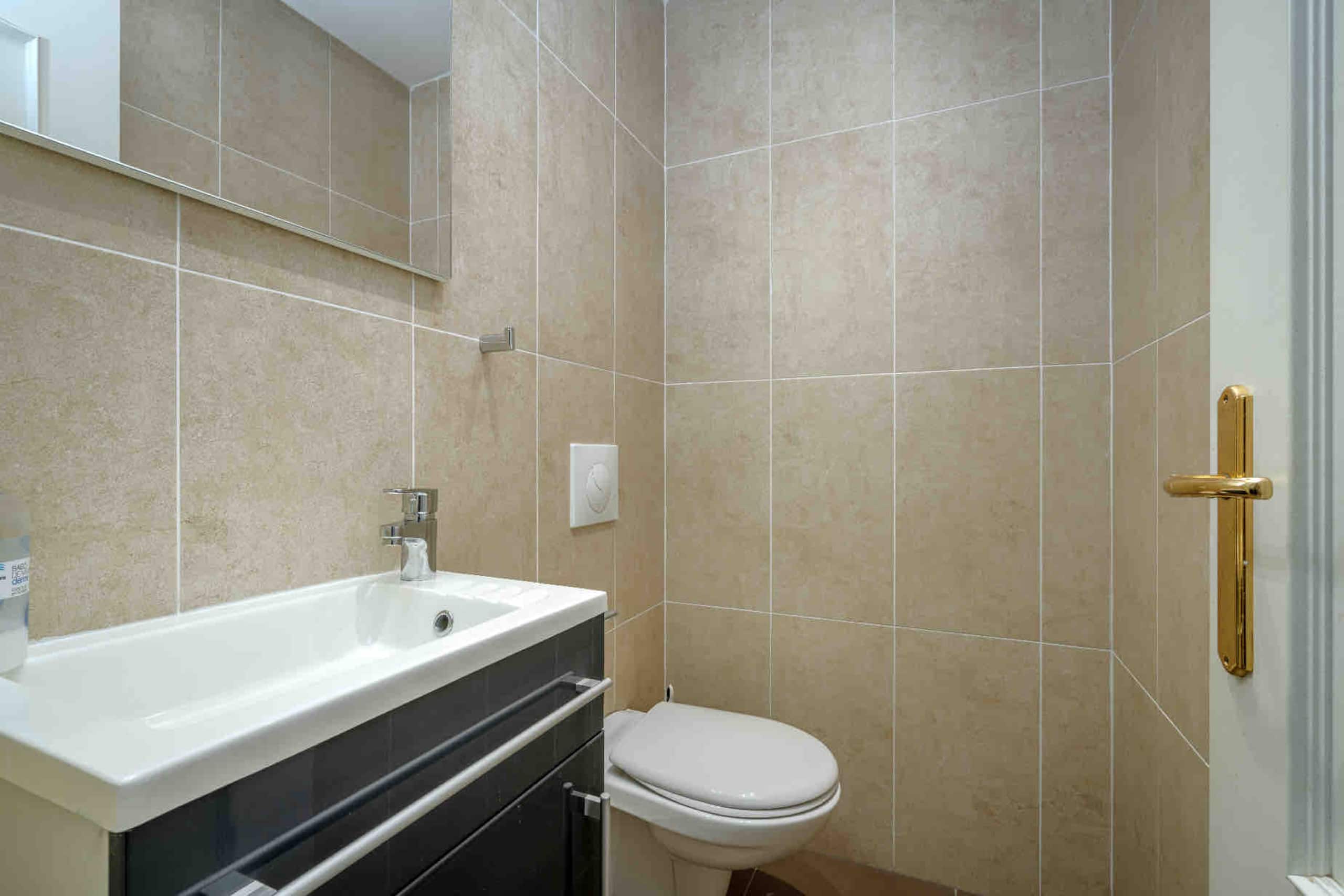 Guest WC with stone tile and brass hardware