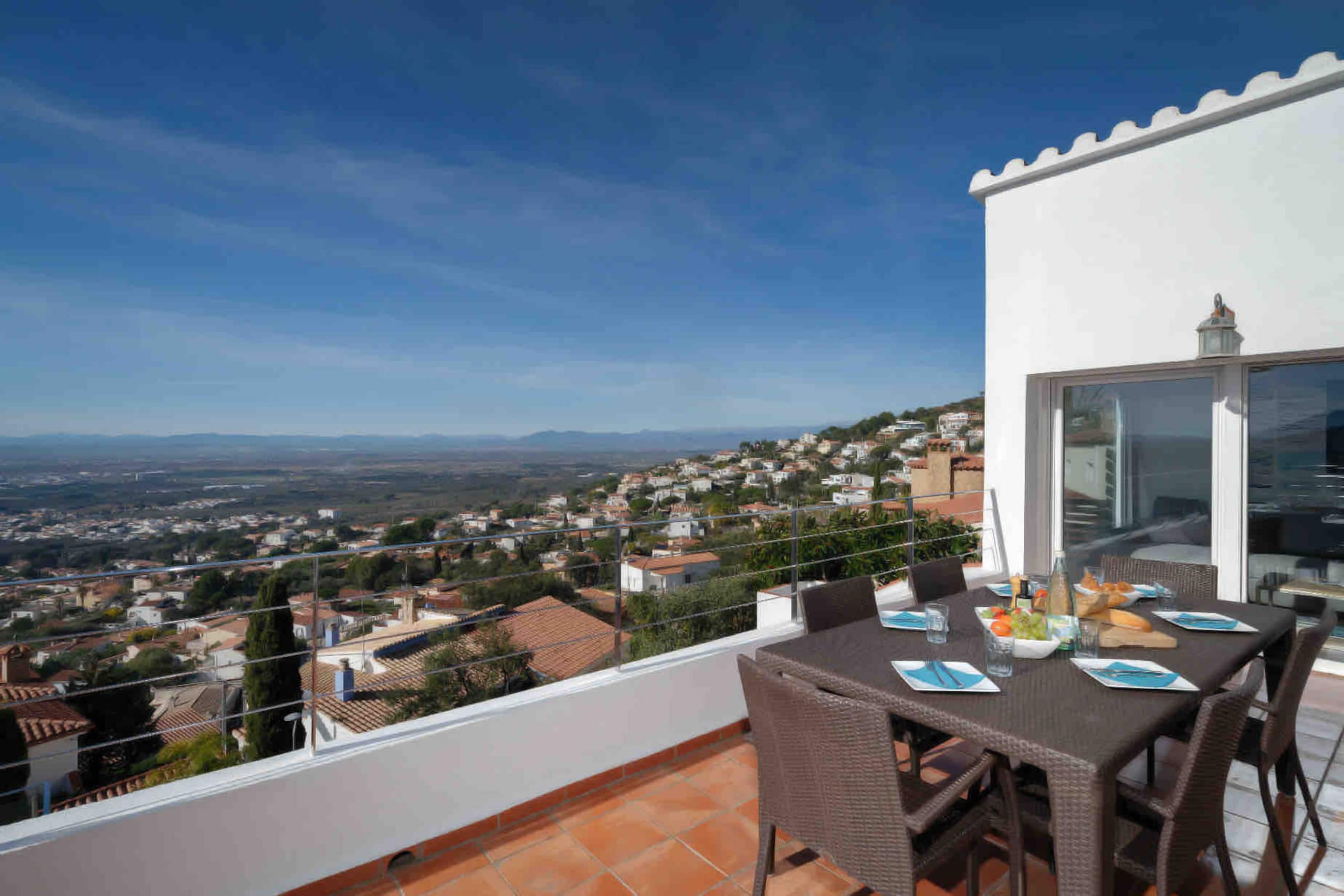 Terrace dining table looking over Roses and the sea