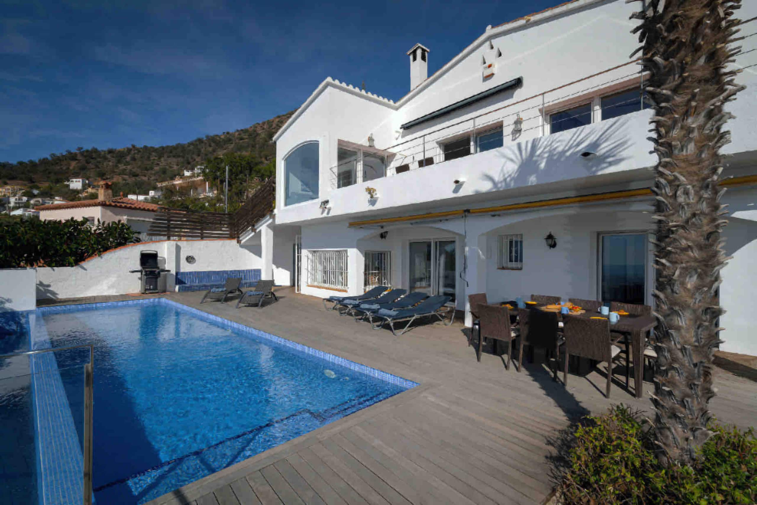 Whitewashed villa and pool deck on a clear winter day