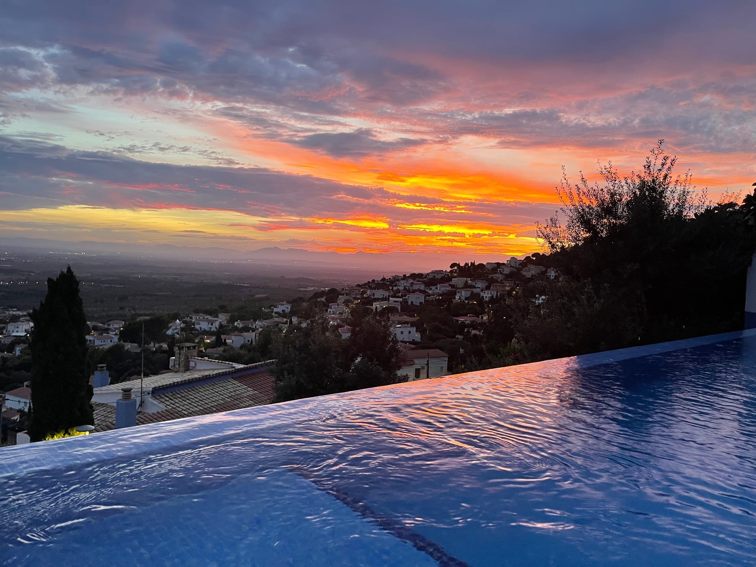 Sunset over the infinity pool with the Bay of Roses below